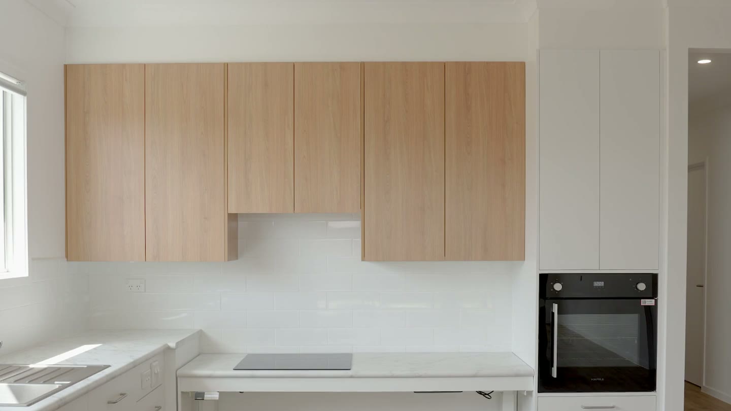 Kitchen with height-adjustable bench and cooktop